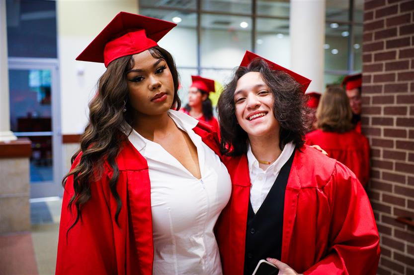 Students in red robes graduate